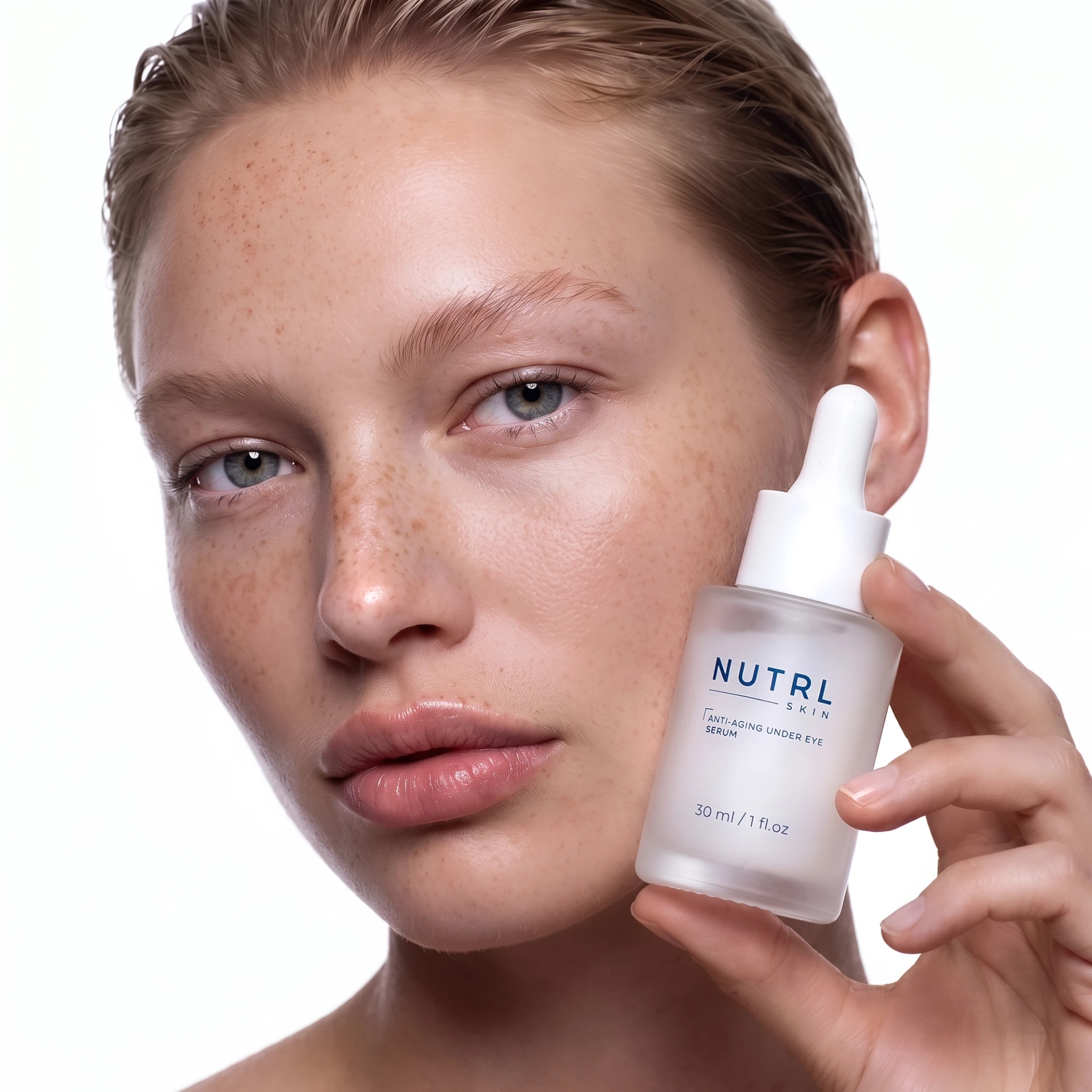 Woman holding a NUTRL Anti-Aging Under Eye Serum bottle beside her face