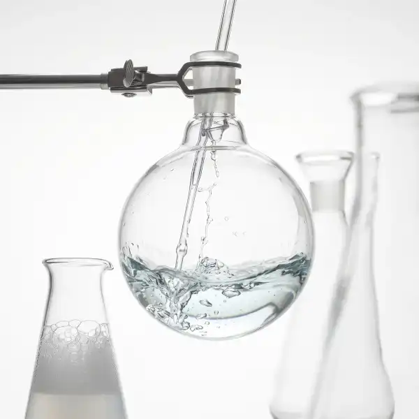 Glass lab flask being filled with clear liquid